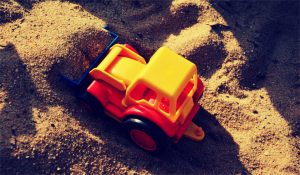 Ein Spielzeugbagger im Sand