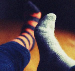 verschiedene Socken an Füßen